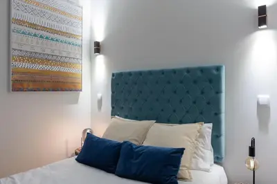 a bedroom with a bed with a blue headboard and pillows at Swimming Pool Luxury House 2 in Porto