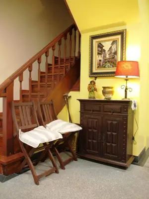 a room with a chair and a staircase with a lamp at 107 Rosario, Guesthouse in Porto