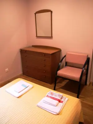 a bedroom with a dresser and a bed and a chair at 107 Rosario, Guesthouse in Porto