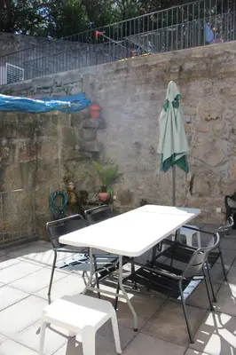 a table and chairs and an umbrella on a patio at 107 Rosario, Guesthouse in Porto