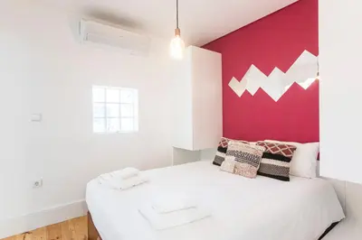 a bedroom with a white bed with a red wall at Sunset Flat Santa Catarina in Porto