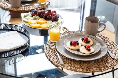 a table with a plate of food on a glass table at Sunset Flat Santa Catarina in Porto