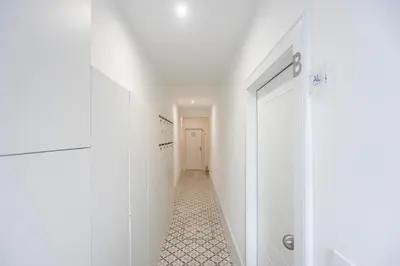 a hallway with white walls and a white door at Sunset Flat Santa Catarina in Porto