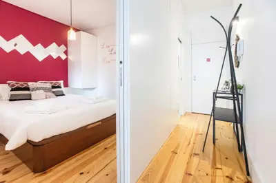 a bedroom with a bed and a red wall at Sunset Flat Santa Catarina in Porto