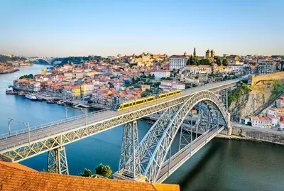 a train crossing a bridge over a river at Porto Wine Loft Duplex with swimming pool in Vila Nova de Gaia