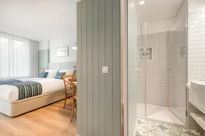 a bedroom with a bed and a bathroom with a shower at 7 Bridges Estúdios- Porto-houses and suites in Porto