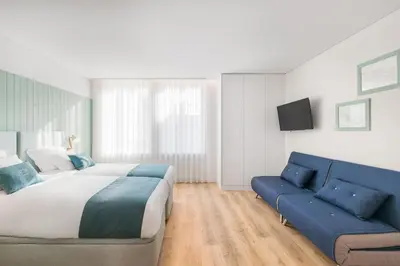 a bedroom with a bed and a blue couch at 7 Bridges Estúdios- Porto-houses and suites in Porto