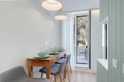 a dining room with a wooden table and chairs at 7 Bridges Estúdios- Porto-houses and suites in Porto