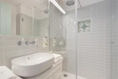 a white bathroom with a sink and a shower at 7 Bridges Estúdios- Porto-houses and suites in Porto