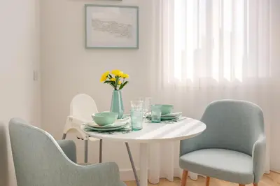 a white table with chairs and a vase of flowers on it at 7 Bridges Estúdios- Porto-houses and suites in Porto
