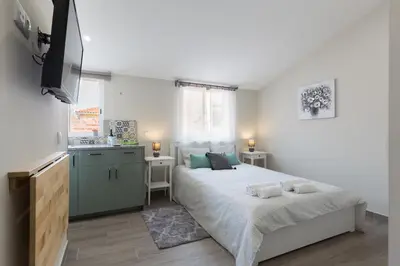 a bedroom with a large bed and a kitchen at OportoHost Cozy Studios in Porto