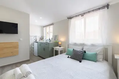 a bedroom with a white bed with a tv on the wall at OportoHost Cozy Studios in Porto