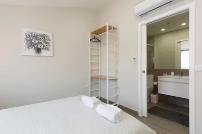 a white bathroom with a bed and a sink at OportoHost Cozy Studios in Porto