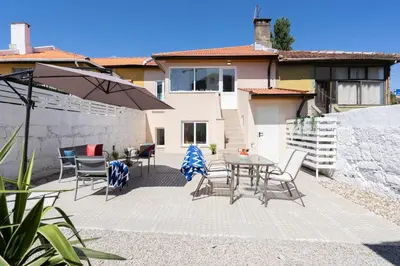 a patio with a table and chairs and an umbrella at OportoHost Dragão Duplex in Porto
