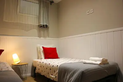 a bedroom with two beds and a red pillow at OportoHost Campanhã in Porto