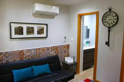 a living room with a couch and a clock on the wall at OportoHost Campanhã in Porto