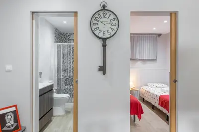 a clock hanging on a wall in a bedroom at OportoHost Campanhã in Porto