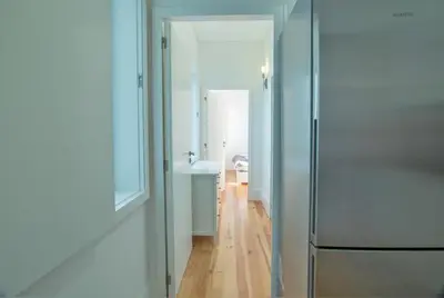 a hallway with a glass door leading to a bathroom at Janelas de São Bento 3 by Porto City Hosts in Porto
