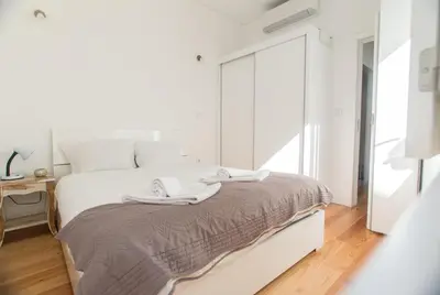 a white bedroom with a bed and a window at Janelas de São Bento 3 by Porto City Hosts in Porto
