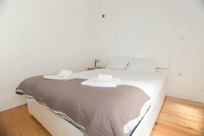 a white bed with two towels on top of it at Janelas de São Bento 3 by Porto City Hosts in Porto