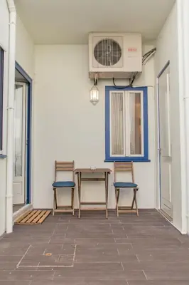 a patio with two chairs and a table and a fan at Janelas de São Bento 3 by Porto City Hosts in Porto