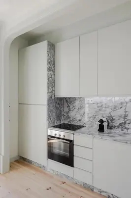 a white kitchen with white cabinets and a stove at Charming Camões Apartment in Porto with AC & Wi-Fi in Porto