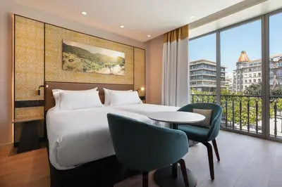 a hotel room with a bed and a table and chairs at Eurostars Aliados in Porto