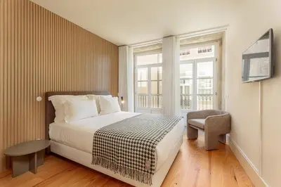 a bedroom with a bed and a chair and a window at YOUROPO - Flores in Porto