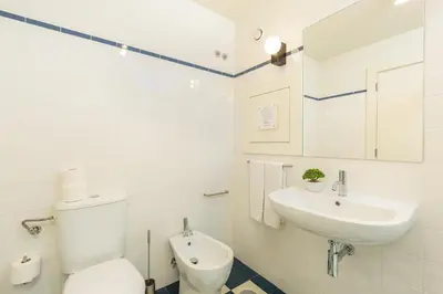 a white bathroom with a toilet and a sink at YOUROPO - Flores in Porto