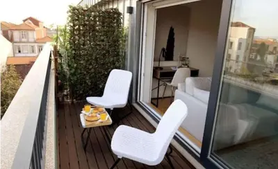 a balcony with white chairs and a table on a balcony at Porto Pool Spot in Porto