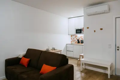 a living room with a couch and a kitchen at Villa Teresa apartamentos in Vila Nova de Gaia