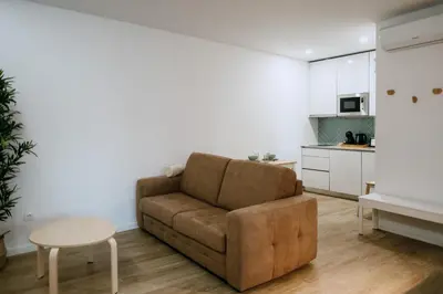 a living room with a couch and a table and a kitchen at Villa Teresa apartamentos in Vila Nova de Gaia