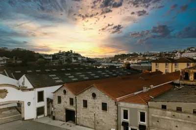 an old building with a sunset in the background at Villa Teresa apartamentos in Vila Nova de Gaia