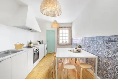 a kitchen with a white table and stools in it at Charming Historic 31 Janeiro Street in Porto