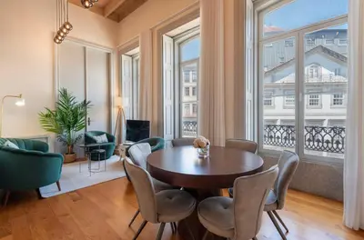 a dining room with a table and chairs and windows at LovelyStay - Deluxe 2BR Duplex with Splendid View in Porto