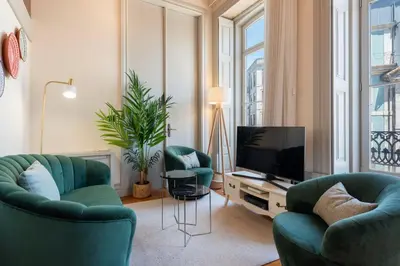 a living room with two green chairs and a television at LovelyStay - Deluxe 2BR Duplex with Splendid View in Porto
