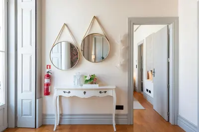 a hallway with two mirrors and a white console table at LovelyStay - Deluxe 2BR Duplex with Splendid View in Porto