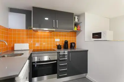a kitchen with stainless steel appliances and orange tiles at O´Porto Outeiro Flat in Porto