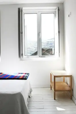 a white room with a bed and a window at O´Porto Outeiro Flat in Porto
