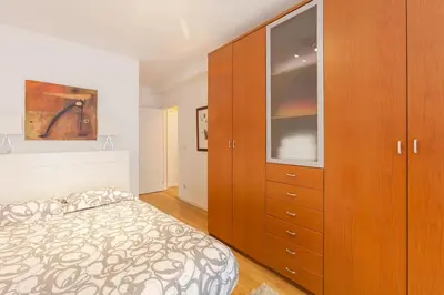 a bedroom with a bed and a large wooden cabinet at O´Porto Fontinha Flat in Porto