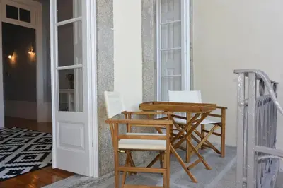 a wooden table and chairs sitting next to a door at Bonjardim 466 - Historic Townhouse in Porto