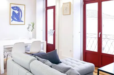 a living room with a white couch and a red door at Artury Porto in Porto