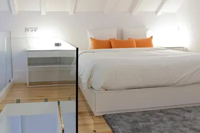 a bedroom with a white bed and a glass table at Artury Porto in Porto