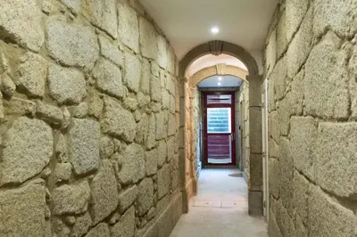 a hallway with a stone wall and a red door at Artury Porto in Porto