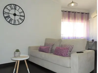 a living room with a couch and a clock on the wall at Rendez Vous Porto II in Porto