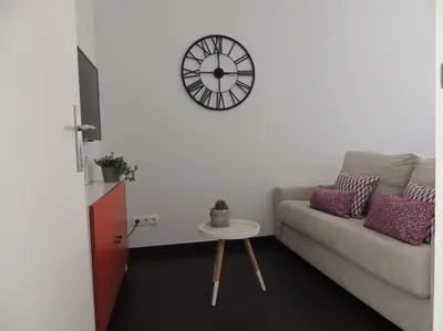 a living room with a couch and a clock on the wall at Rendez Vous Porto II in Porto