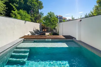 a swimming pool with blue water in a backyard at Villa Almada - Amazing City Centre Villa with Private Pool in Porto