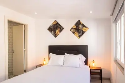 a bedroom with a white bed and two lamps at Alto da Lapa House w Parking by LovelyStay in Porto