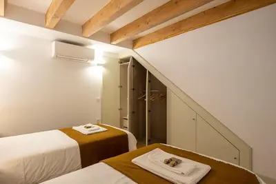 a small room with two beds and a staircase at CC Downtown Palace - A in Porto