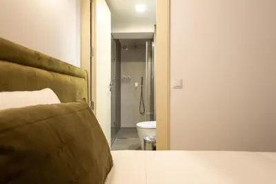 a bedroom with a bed and a bathroom with a toilet at CC Downtown Palace - D in Porto
